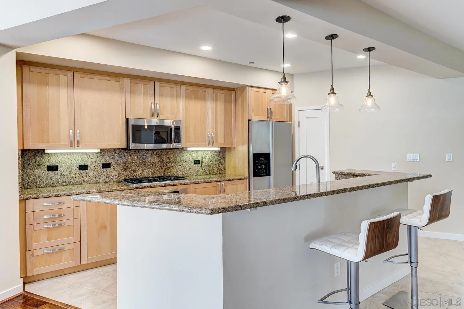 5440 La Jolla Boulevard, Unit E208 La Jolla, CA 92037 - Photo 4 of 35 a kitchen with stainless steel appliances granite countertop a sink a stove a refrigerator a microwave oven with white cabinets and a wooden floor