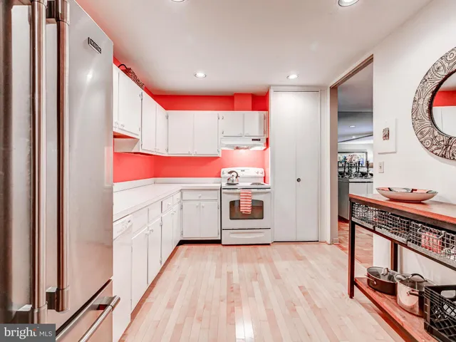 a kitchen with stainless steel appliances a stove top oven a sink and a refrigerator