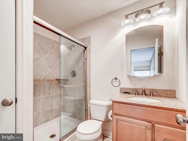 a bathroom with a shower a sink a toilet and mirror