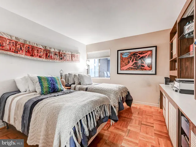 a bedroom with two beds and a painting on the wall