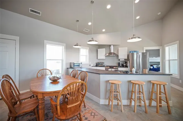 a dining room with stainless steel appliances granite countertop a dining table and chairs