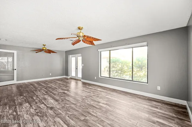 a view of a room with wooden floor and windows