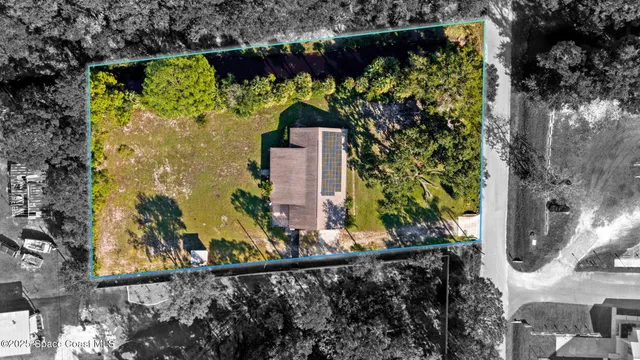 an aerial view of a house with a yard