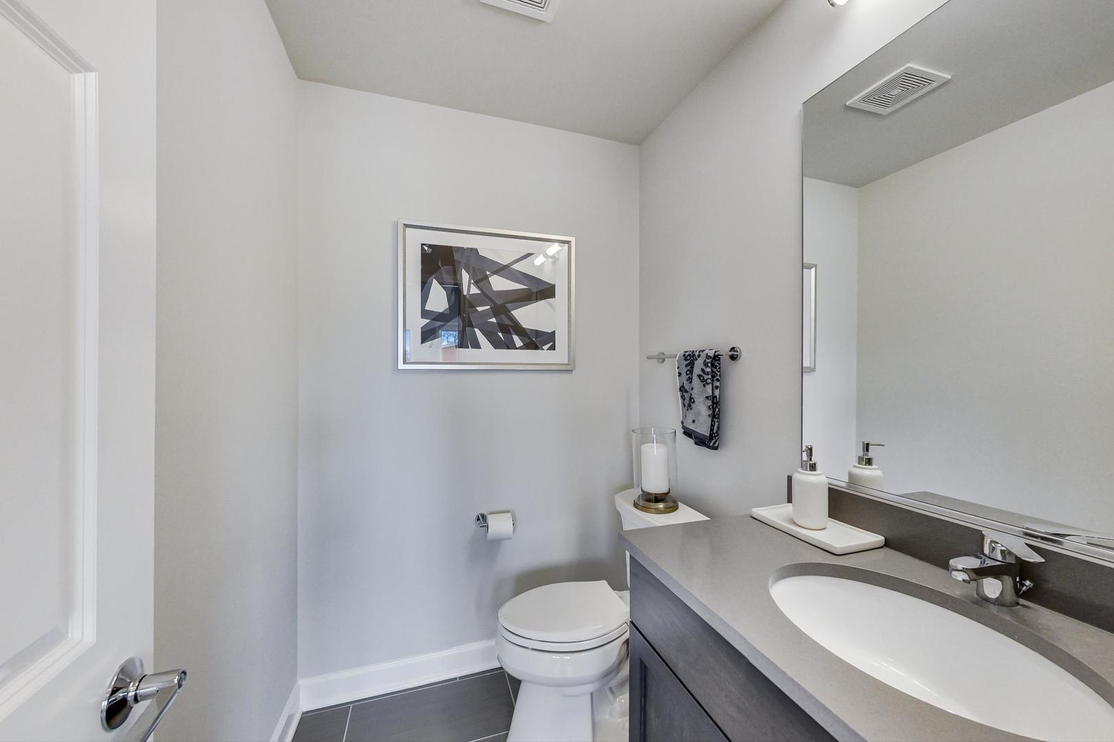 1259 Shermer Road Northbrook, IL 60062 - Photo 4 of 32 a bathroom with a granite countertop toilet a sink and a mirror