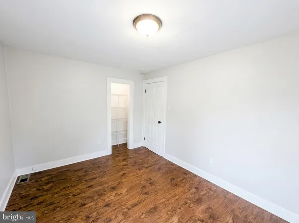 a view of a room with wooden floor and a window