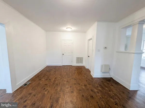 a view of empty room with wooden floor