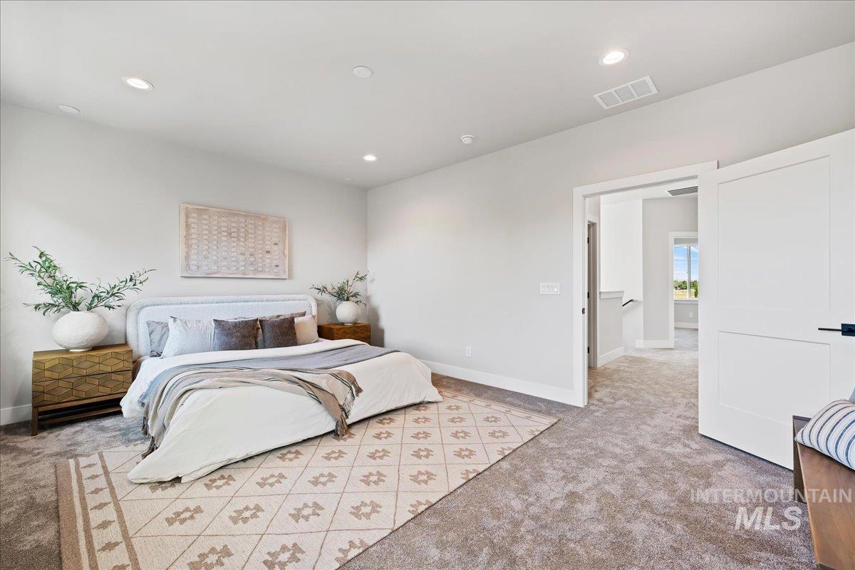 985 West Malbar Street Meridian, ID 83646 - Photo 19 of 39 Spacious room featuring neutral carpeting, recessed lighting, and a wide entryway with a modern white door