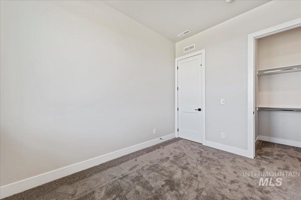 985 West Malbar Street Meridian, ID 83646 - Photo 34 of 39 Room featuring light gray walls, gray carpet flooring, and white baseboards
