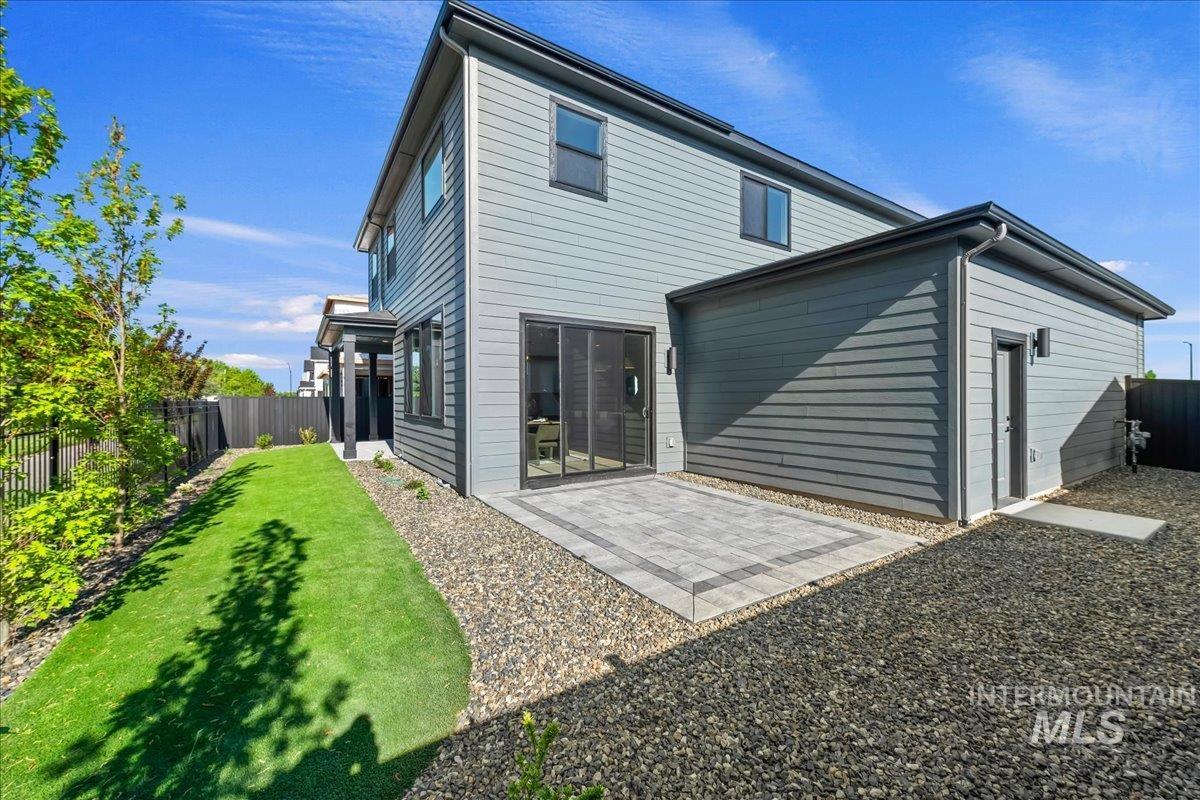 985 West Malbar Street Meridian, ID 83646 - Photo 38 of 39 Modern exterior featuring horizontal siding, a private patio with paver stones, and a manicured lawn