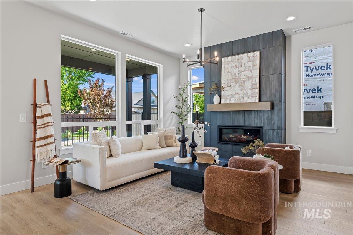 985 West Malbar Street Meridian, ID 83646 - Photo 5 of 39 Living space featuring a tiled fireplace with a built-in electric firebox and a wood mantel
