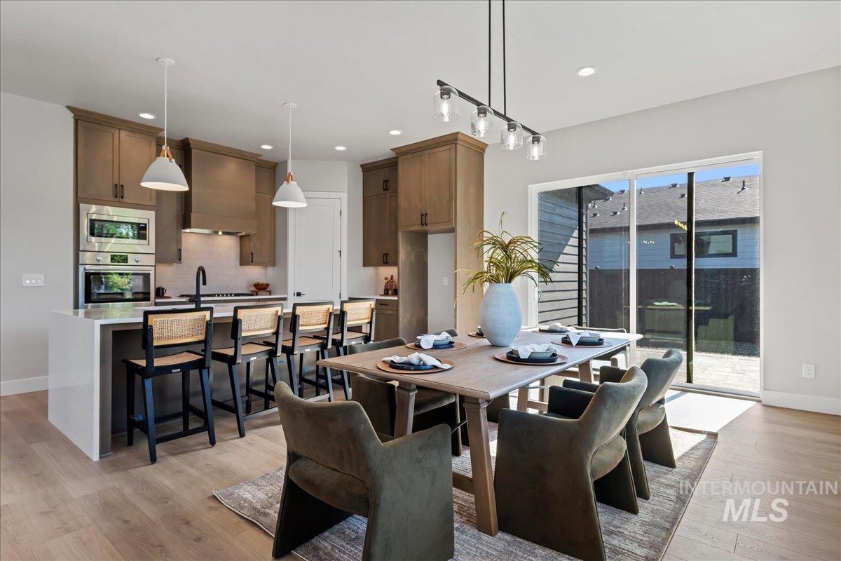 985 West Malbar Street Meridian, ID 83646 - Photo 9 of 39 Open-concept kitchen and dining area featuring wood-finish flooring, recessed lighting, and a sliding glass door