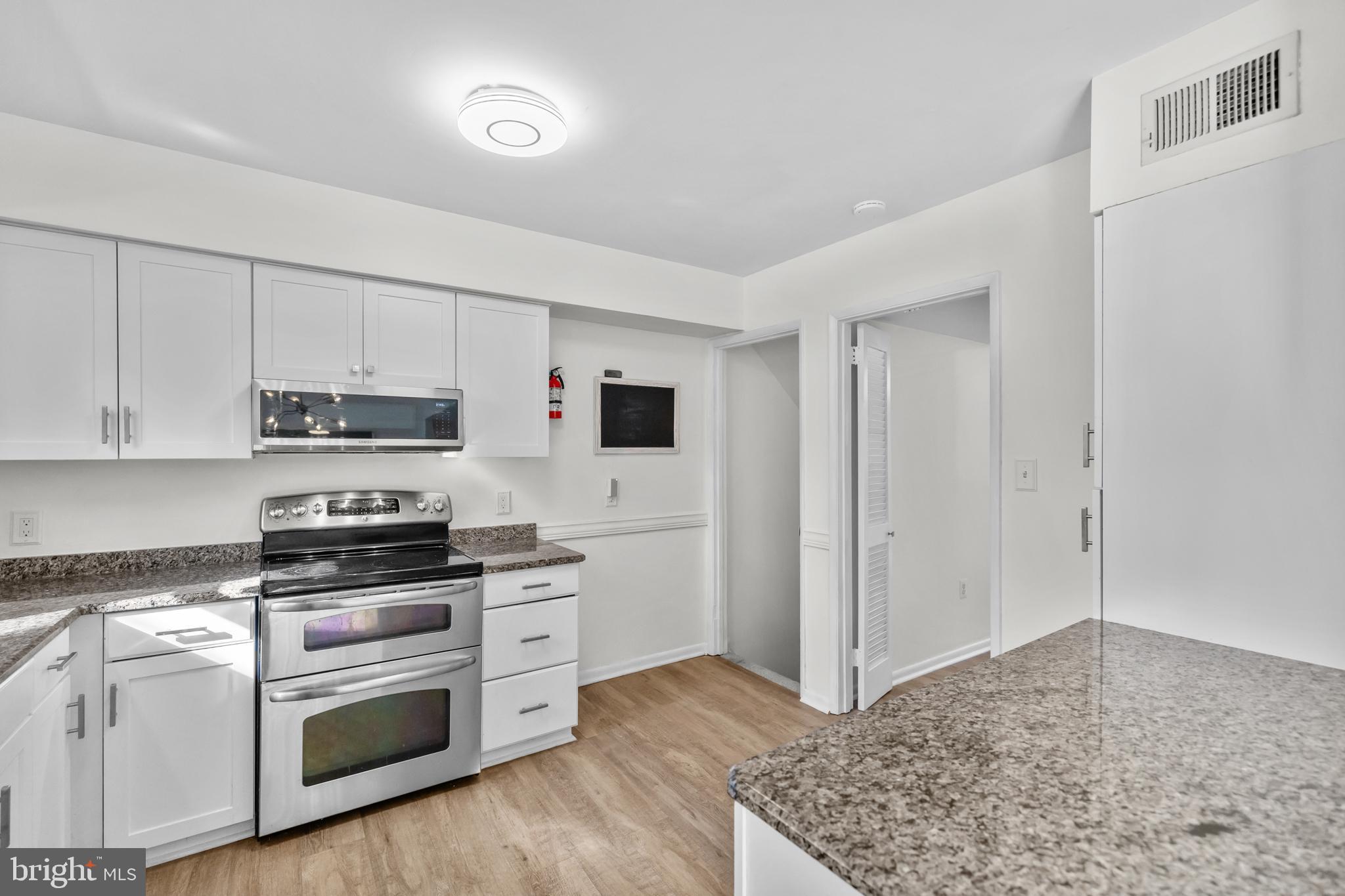 2320 Emerald Heights Court Reston, VA 20191 - Photo 17 of 44 a kitchen with stainless steel appliances white cabinets and a stove