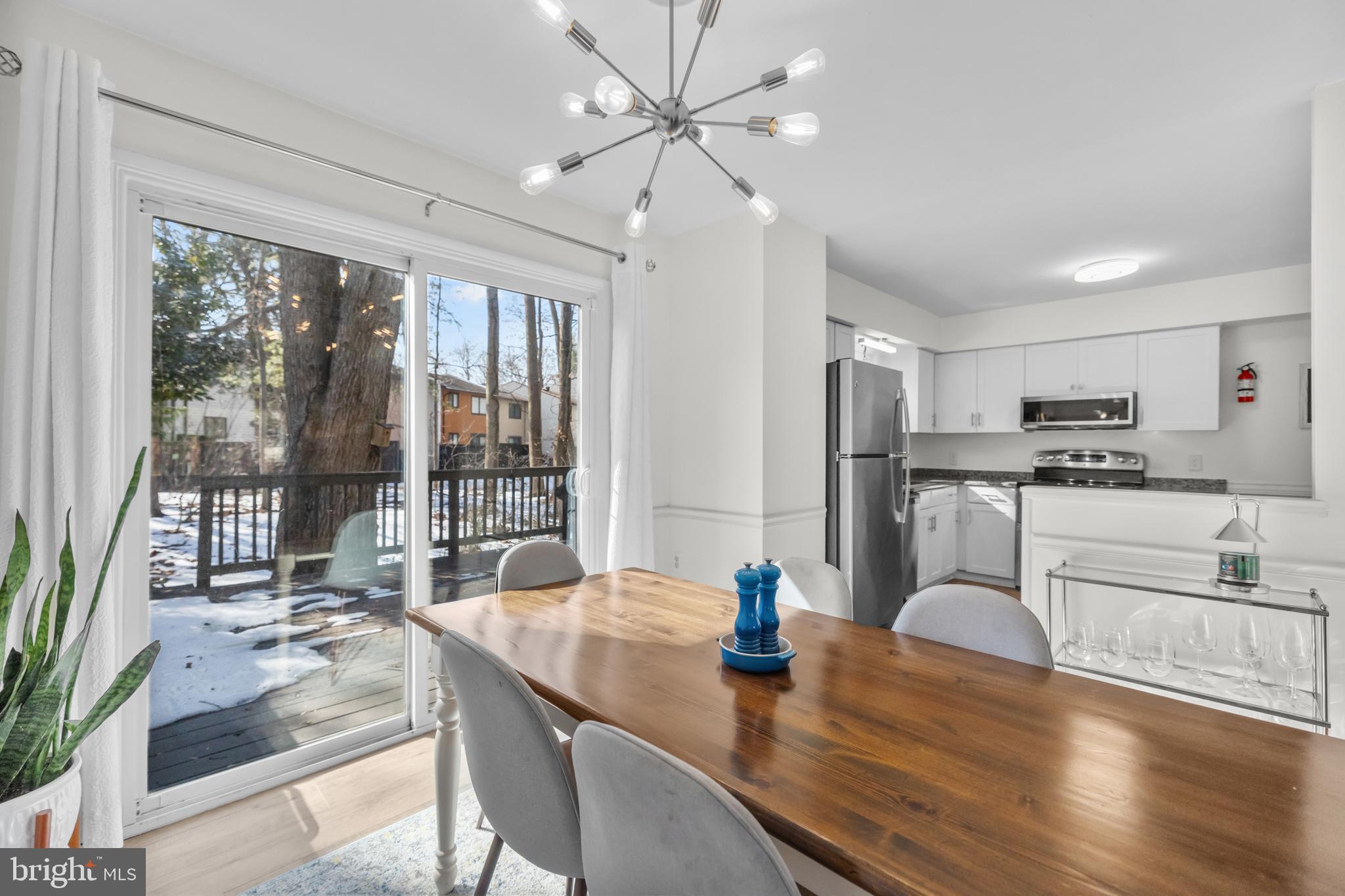2320 Emerald Heights Court Reston, VA 20191 - Photo 10 of 44 a kitchen with stainless steel appliances granite countertop a stove refrigerator a dining table and chairs with wooden floor
