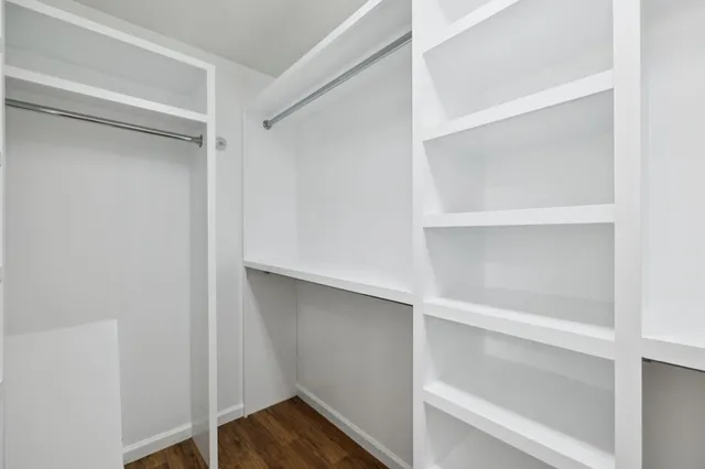 a view of walk in closet with empty racks