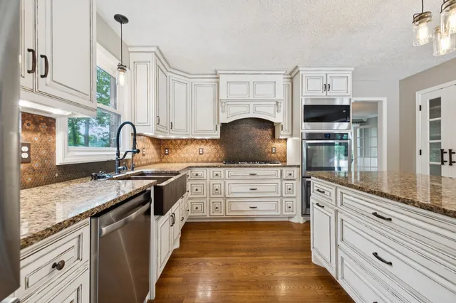 a kitchen with granite countertop a sink and cabinets