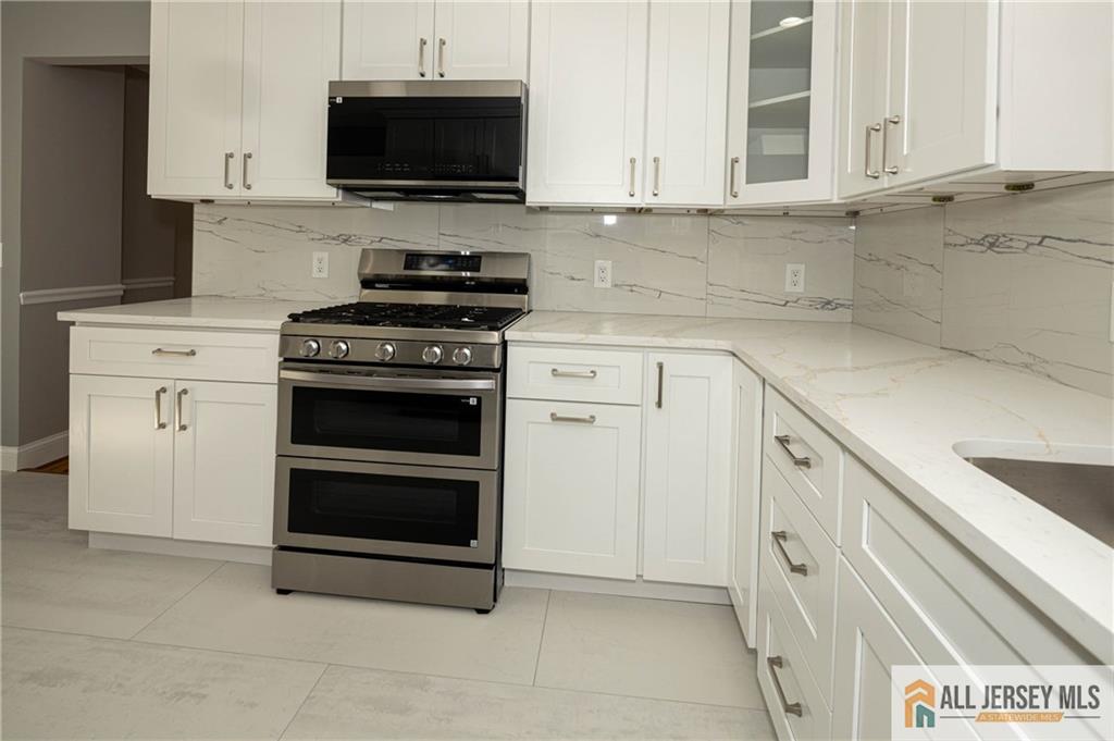 278 Rector Street Perth Amboy, NJ 08861 - Photo 12 of 47 a kitchen with stainless steel appliances a stove a microwave and a sink