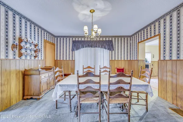 a view of a dining room with furniture and chandelier