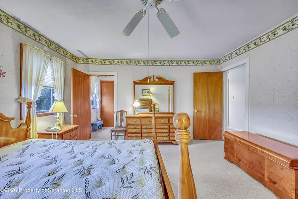 a bedroom with a bed and dresser with mirror