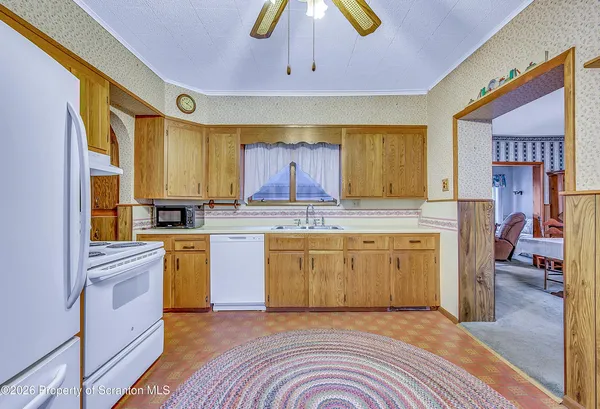 a kitchen with a sink a stove cabinets and wooden floor