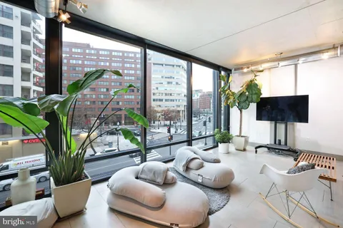 a living room with furniture and a floor to ceiling window