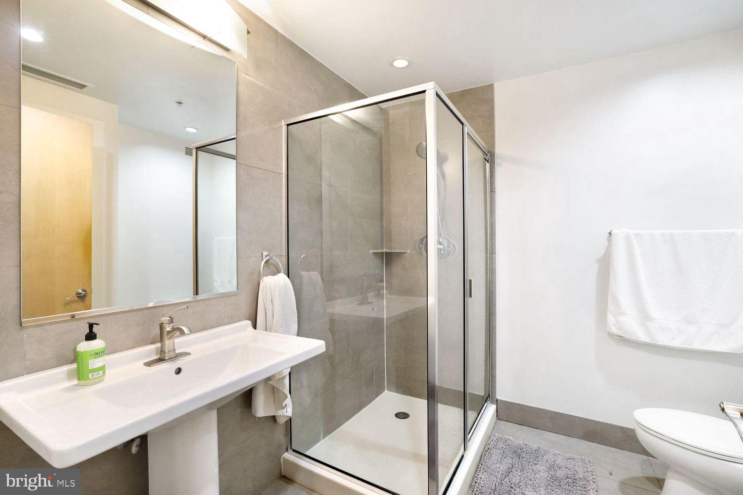 1133 14th Street Northwest, Unit 306 Washington, DC 20005 - Photo 15 of 36 a bathroom with a sink a toilet and shower