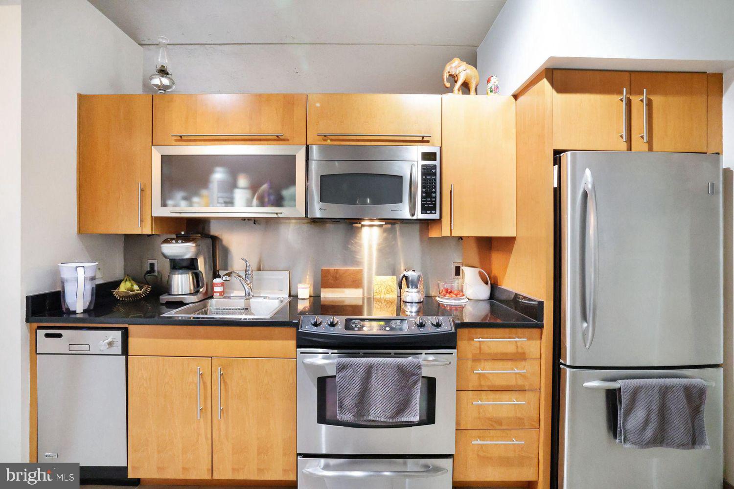1133 14th Street Northwest, Unit 306 Washington, DC 20005 - Photo 5 of 36 a kitchen with stainless steel appliances granite countertop a sink and a refrigerator