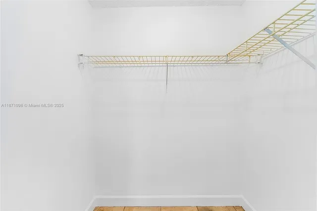 a view of a small space with wooden floor and a window