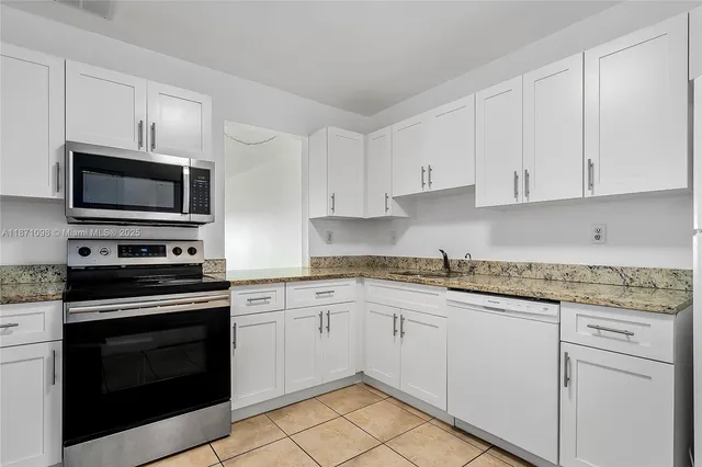 a kitchen with white cabinets and white appliances