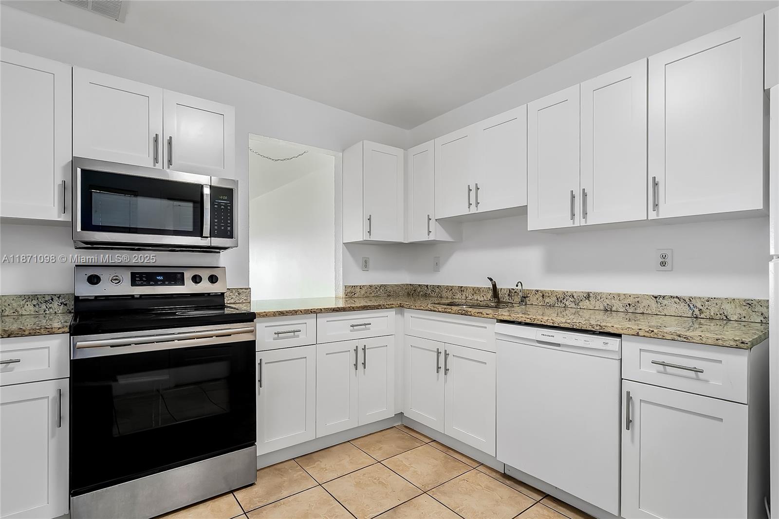 2500 Southwest 81st Avenue, Unit 402 Davie, FL 33324 - Photo 20 of 51 a kitchen with granite countertop white cabinets stainless steel appliances and a sink