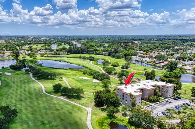 an aerial view of residential houses with outdoor space and lake view