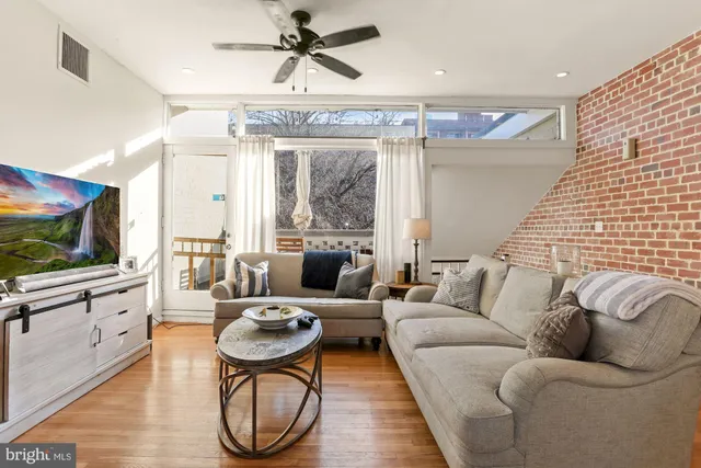 a living room with furniture a flat screen tv and a large window