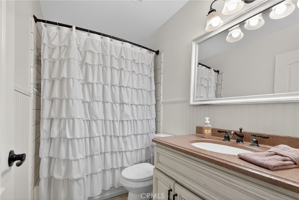 25837 Anderson Lane Stevenson Ranch, CA 91381 - Photo 18 of 22 a bathroom with a sink a toilet and shower curtain