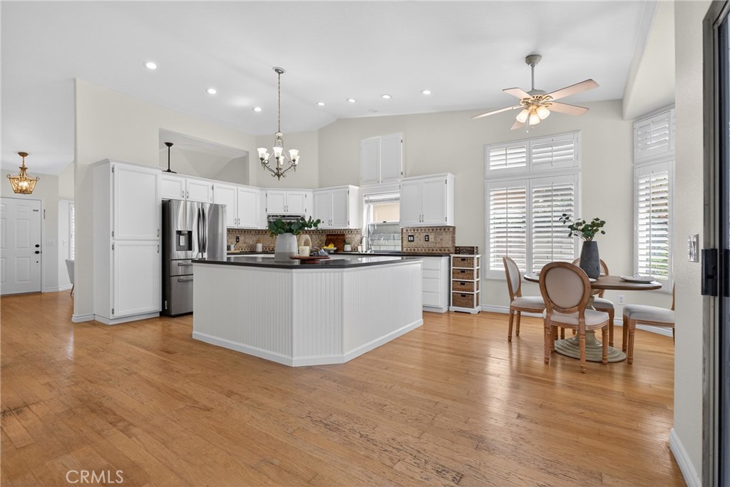 25837 Anderson Lane Stevenson Ranch, CA 91381 - Photo 9 of 22 a kitchen with refrigerator cabinets dining table and chairs