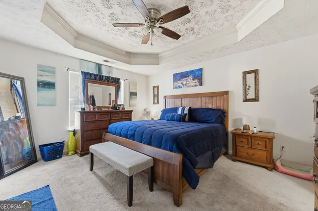 a bedroom with a large bed a flat tv screen and dresser