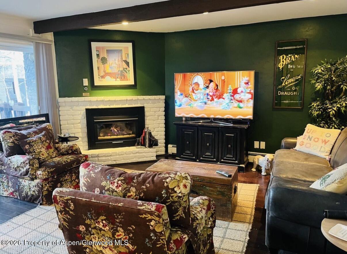 a living room with furniture a flat screen tv and a fireplace