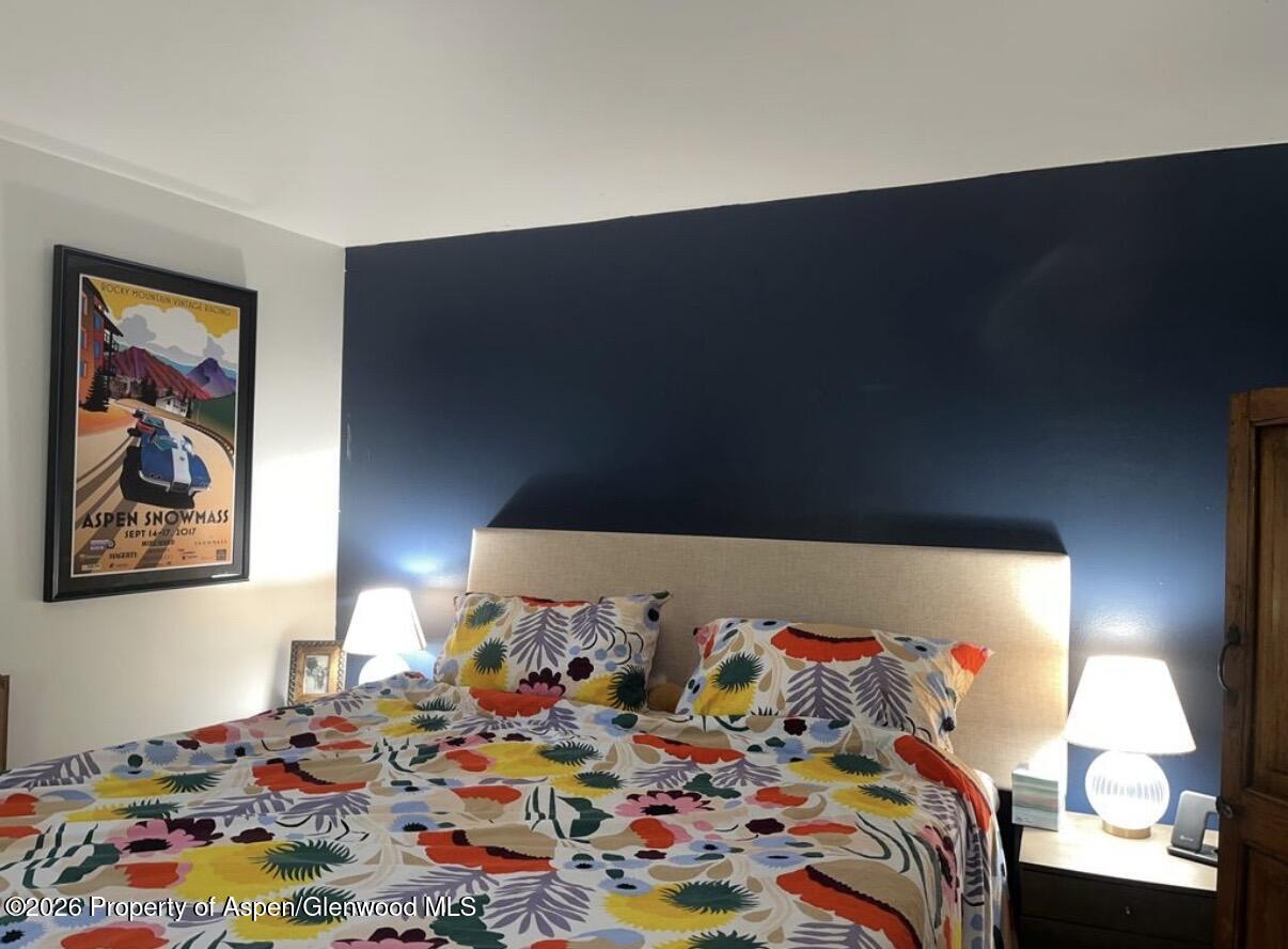 35 Upper Woodbridge Road, Unit 3 Snowmass Village, CO 81615 - Photo 5 of 16 a bed sitting in a bedroom next to a lamp