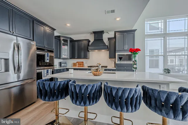 a kitchen with stainless steel appliances granite countertop a refrigerator and a stove top oven