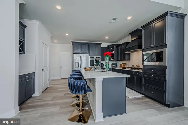 a kitchen with kitchen island granite countertop a sink cabinets and refrigerator