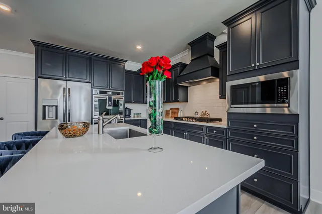 a kitchen with stainless steel appliances a stove refrigerator and microwave