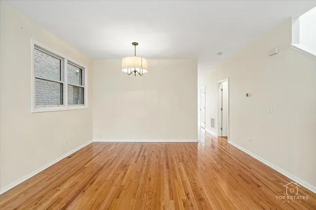 a view of a livingroom with furniture wooden floor chandelier and windows