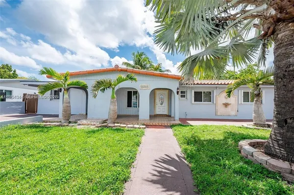 a front view of a house with garden and a patio