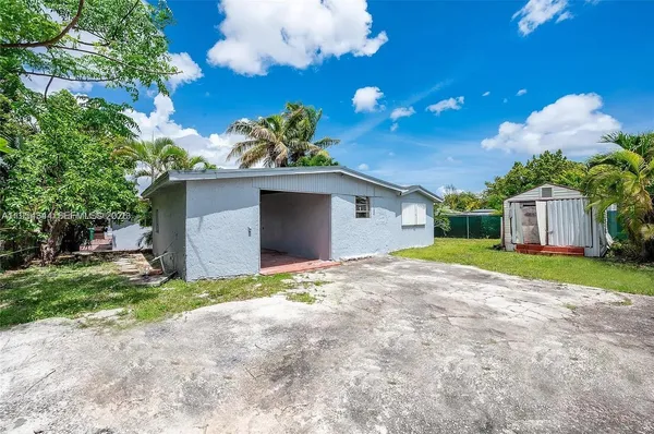 a view of a house with a yard and a large tree