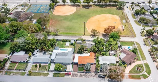an aerial view of residential houses with outdoor space and parking