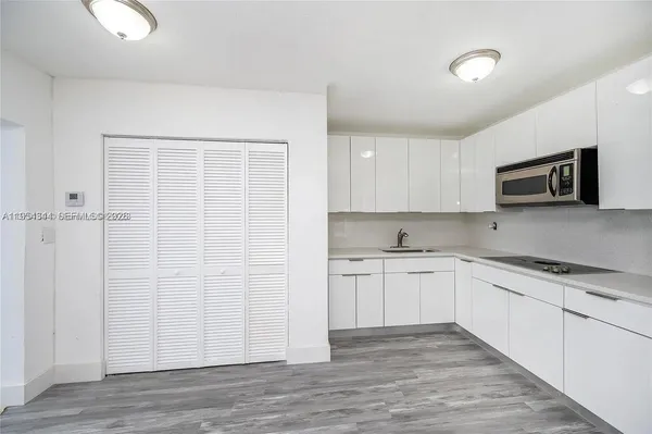 a kitchen with granite countertop white cabinets and white appliances