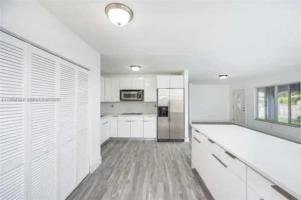 a kitchen with stainless steel appliances a refrigerator and a stove top oven
