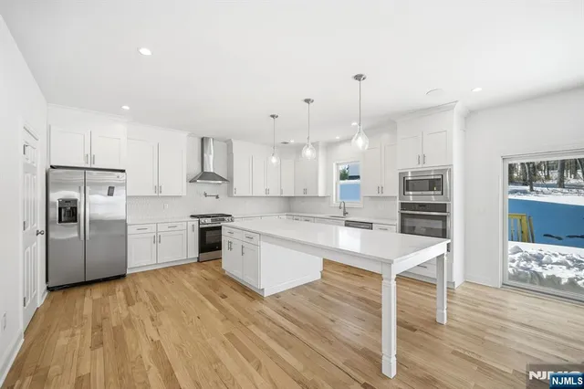 a large kitchen with cabinets wooden floor and stainless steel appliances