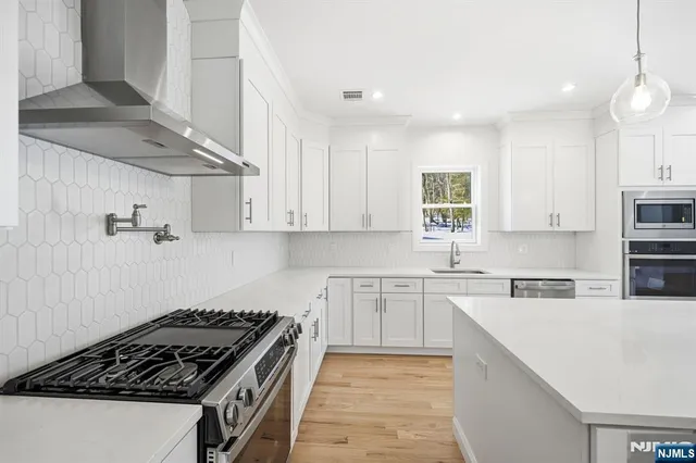 a kitchen with stainless steel appliances granite countertop a sink stove and cabinets