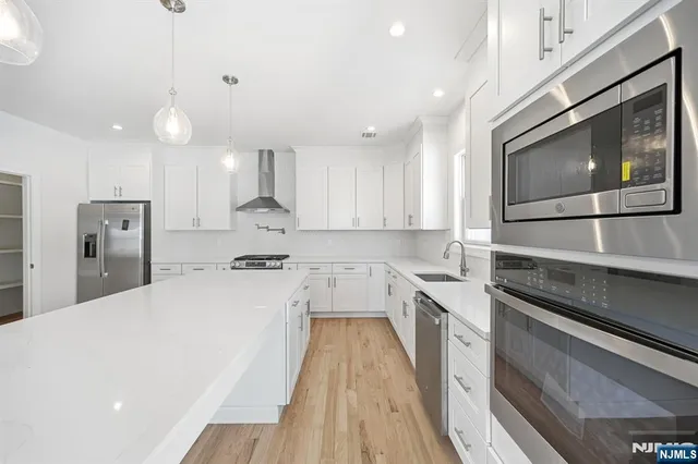 a kitchen with stainless steel appliances a stove sink microwave and cabinets