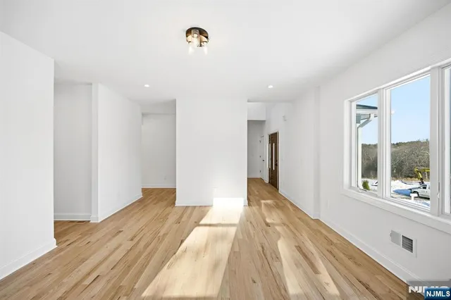 a view of hallway with a large window and wooden floor