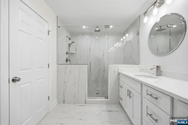 a spacious bathroom with a double vanity sink mirror and shower